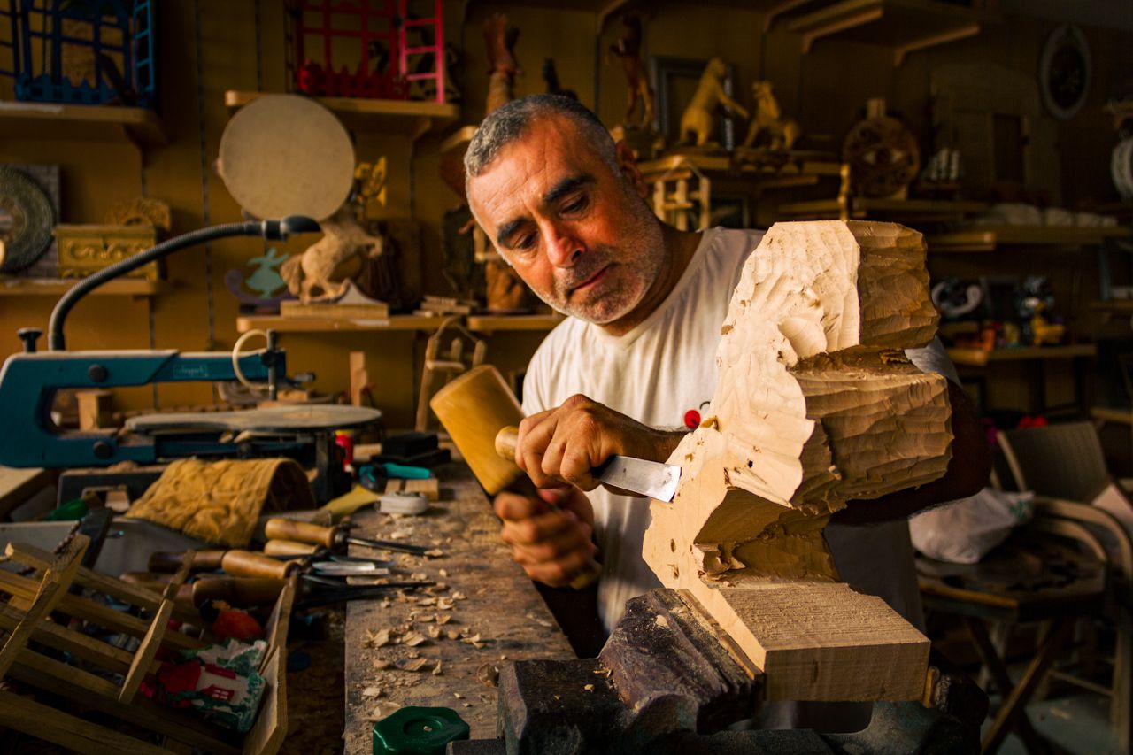 why-choose-us Artisan crafting a wooden sculpture in a well-equipped workshop, showcasing expert woodworking skills.